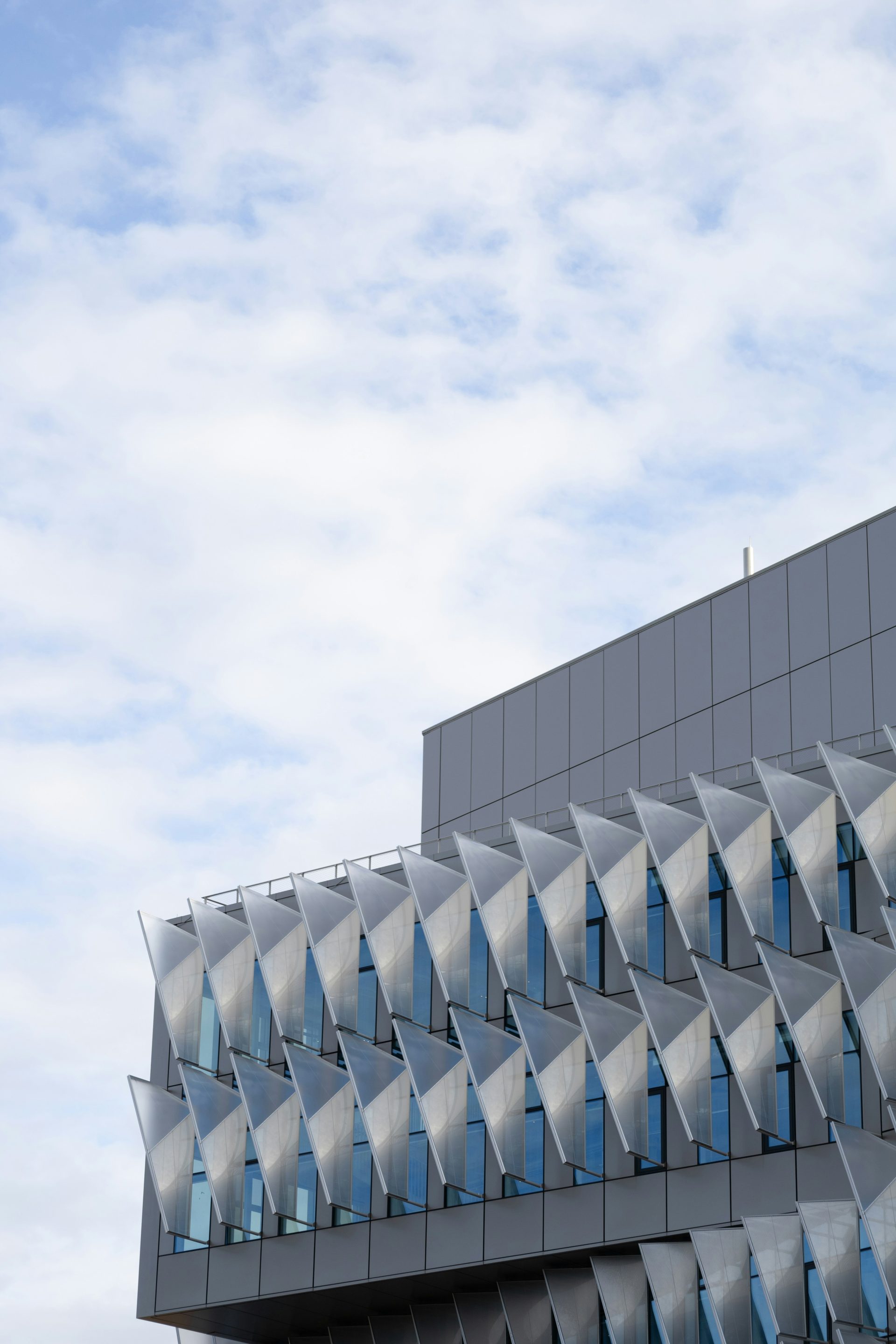 Façade d'immeuble moderne ornée de motifs géométriques se détachant sur le ciel